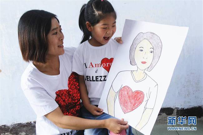 5月10日，在河北唐山市豐潤區(qū)迎賓路幼兒園開展的“媽媽，我愛你”主題活動中，陳悅寧小朋友將自己的繪畫作品送給媽媽作為節(jié)日禮物。 新華社發(fā)（朱大勇 攝）
