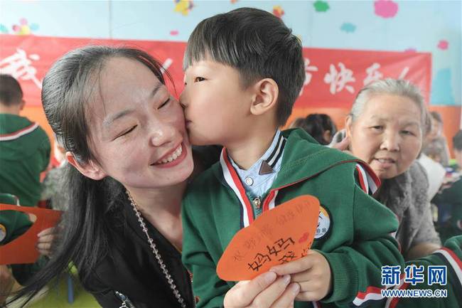 5月10日，在湖北省襄陽市一家幼兒園舉辦的母親節(jié)主題活動中，一名小朋友將自己制作的賀卡獻給媽媽。 新華社發(fā)（安富斌 攝）