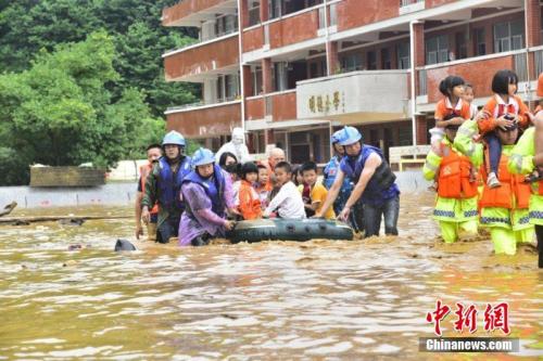6月9日至10日，江西省龍南縣普降暴雨，該縣地勢低洼的楊村鎮(zhèn)中心小學師生被洪水圍困。危急時刻，當?shù)匮杆俳M織武警、消防等力量奔赴救援。由于橡皮艇有限，不少救援人員讓學童們騎在自己肩上，加快撤離被洪水圍困的學校。截至10日17時，該小學1309名師生全部安全轉(zhuǎn)移。文/葉波 王劍 圖/葉波