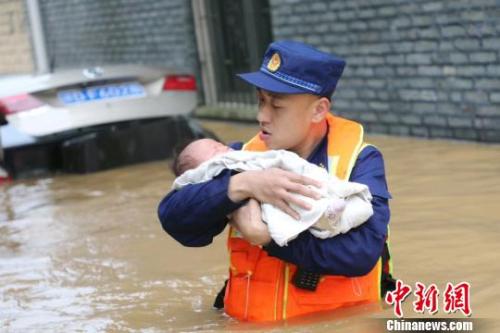6月10日，江西省吉安縣梅塘鄉(xiāng)渡口村，消防員蹚著齊腰深的洪水，小心翼翼地將嬰兒轉(zhuǎn)移到安全地帶?！」逶?攝